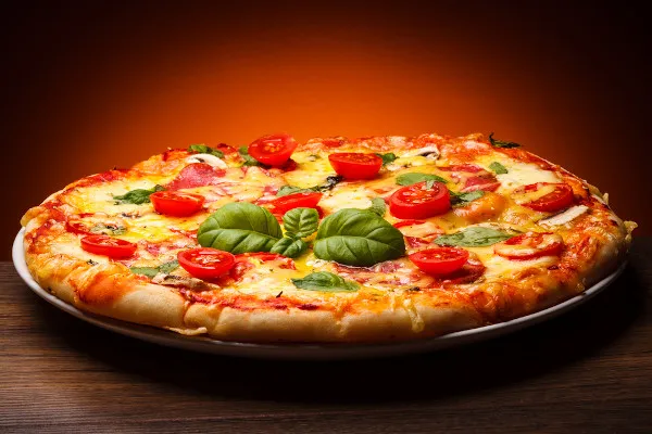 O atributo alt desta imagem está vazio. O nome do arquivo é pizza-italiana-tradicional-com-tomates-e-manjericao-em-alusao-a-historia-da-pizza.webp